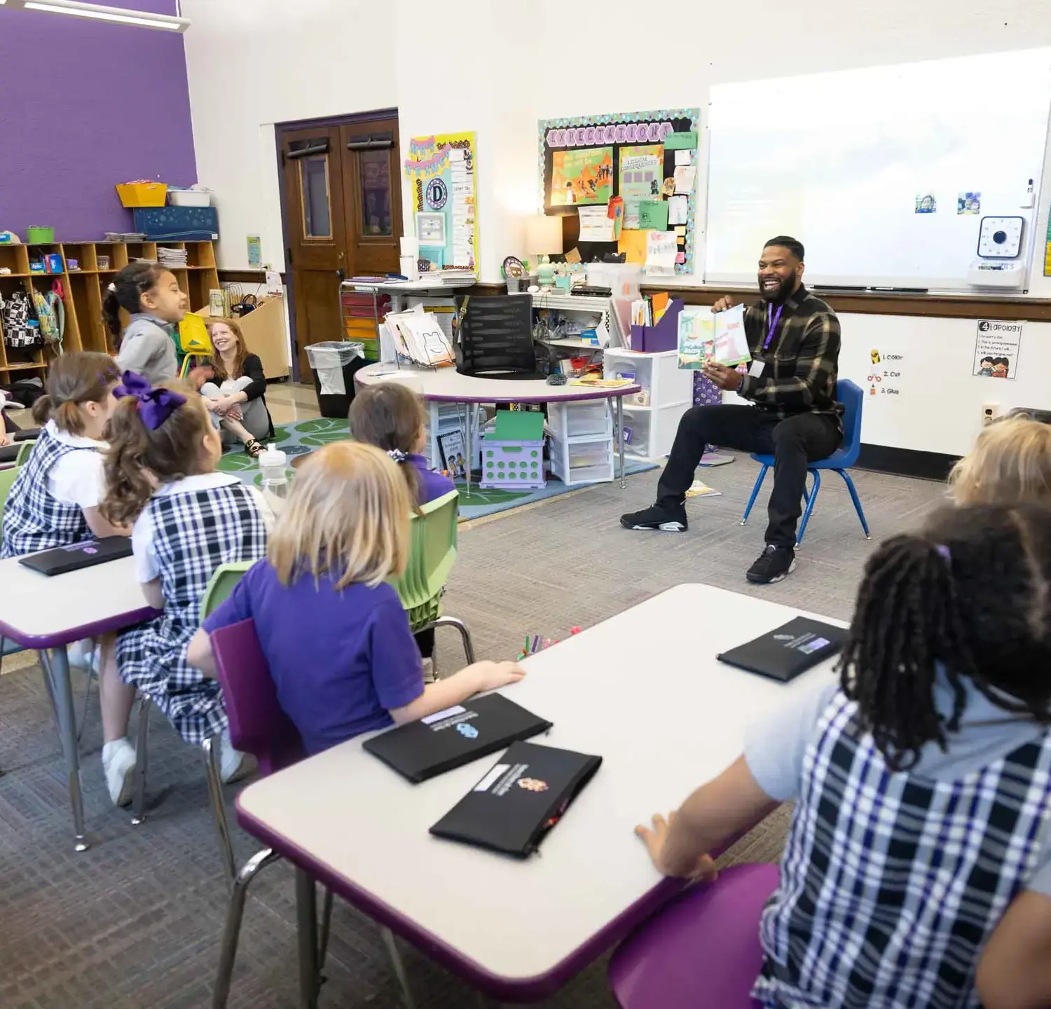 Notre Dame de Sion Grade School teacher reading a book with their class.