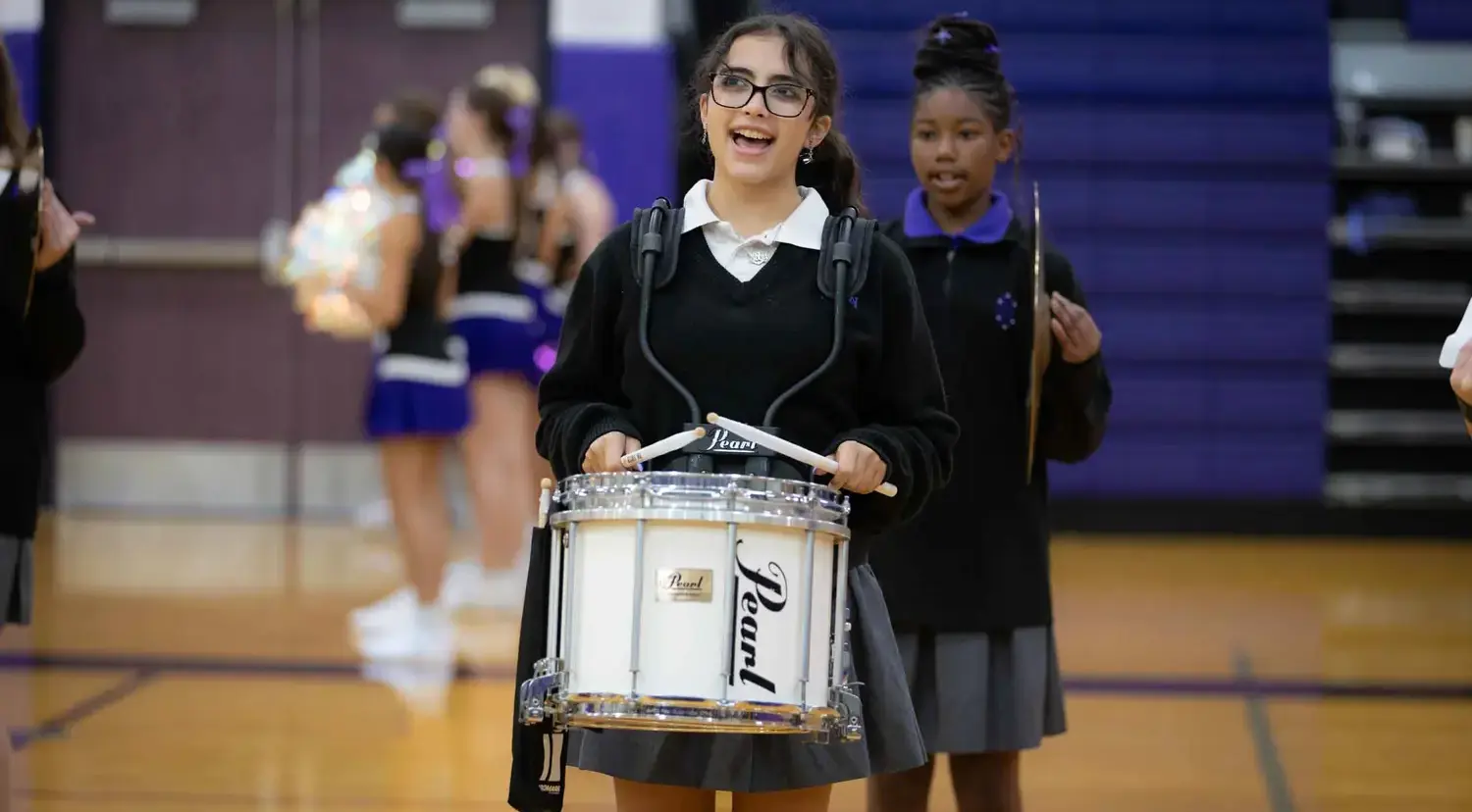Notre Dame de Sion High School student playing percussion at an event.