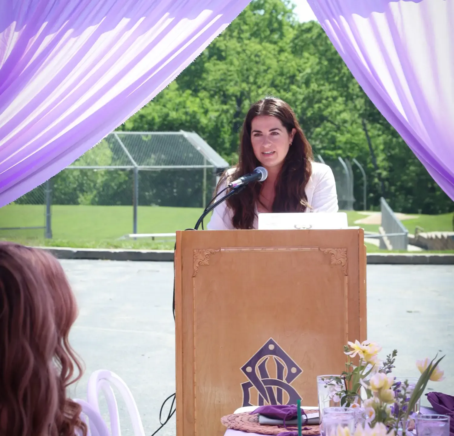Hayley Santell speaking from a lectern at an Alumni Awards event.