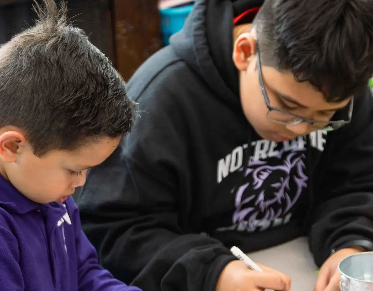 Notre Dame de Sion Grade School students concentrating on drawing a picture together.