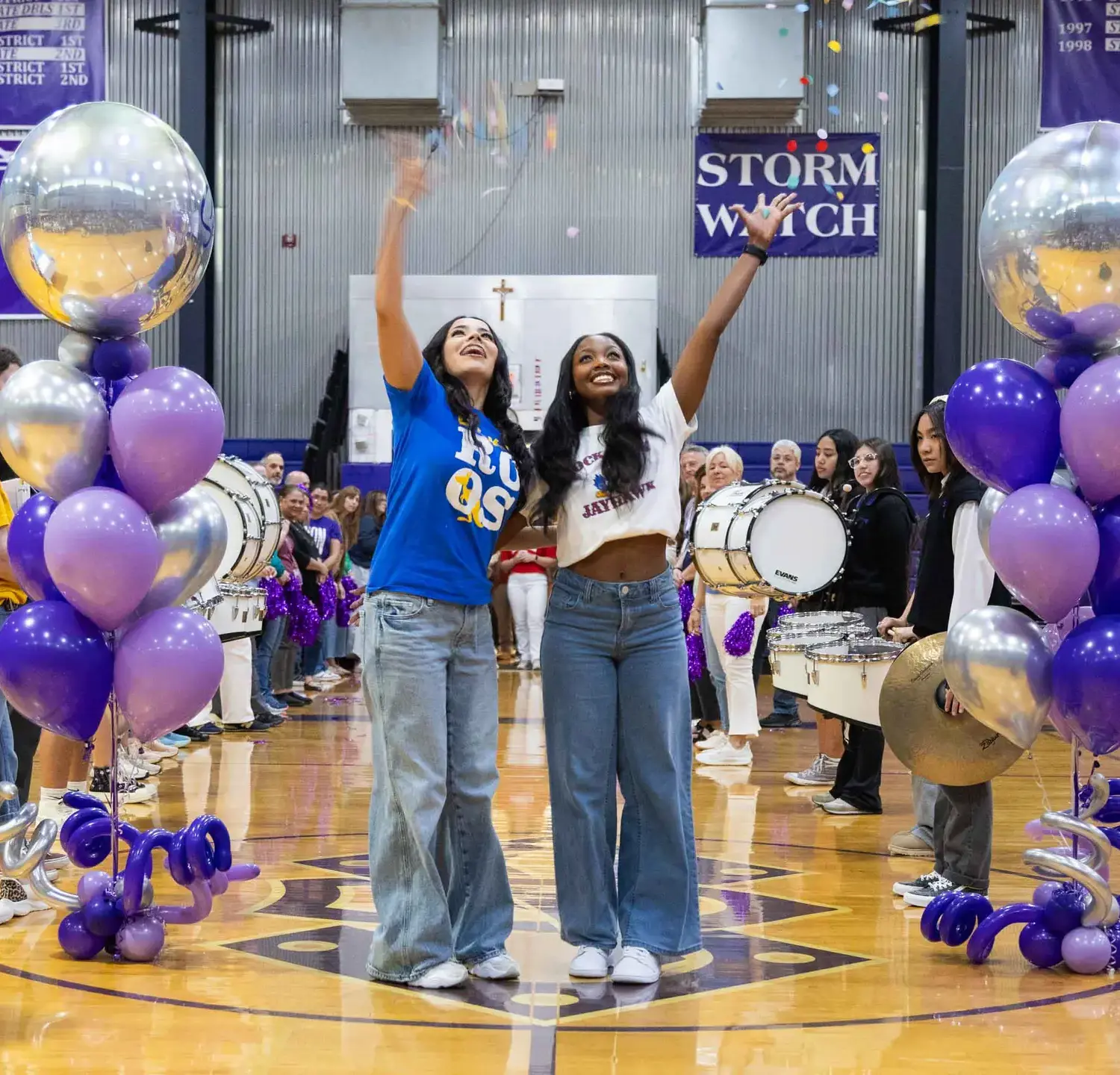 Notre Dame de Sion High School students throwing confetti, smiling elatedly, holding hands, school band, celebration.
