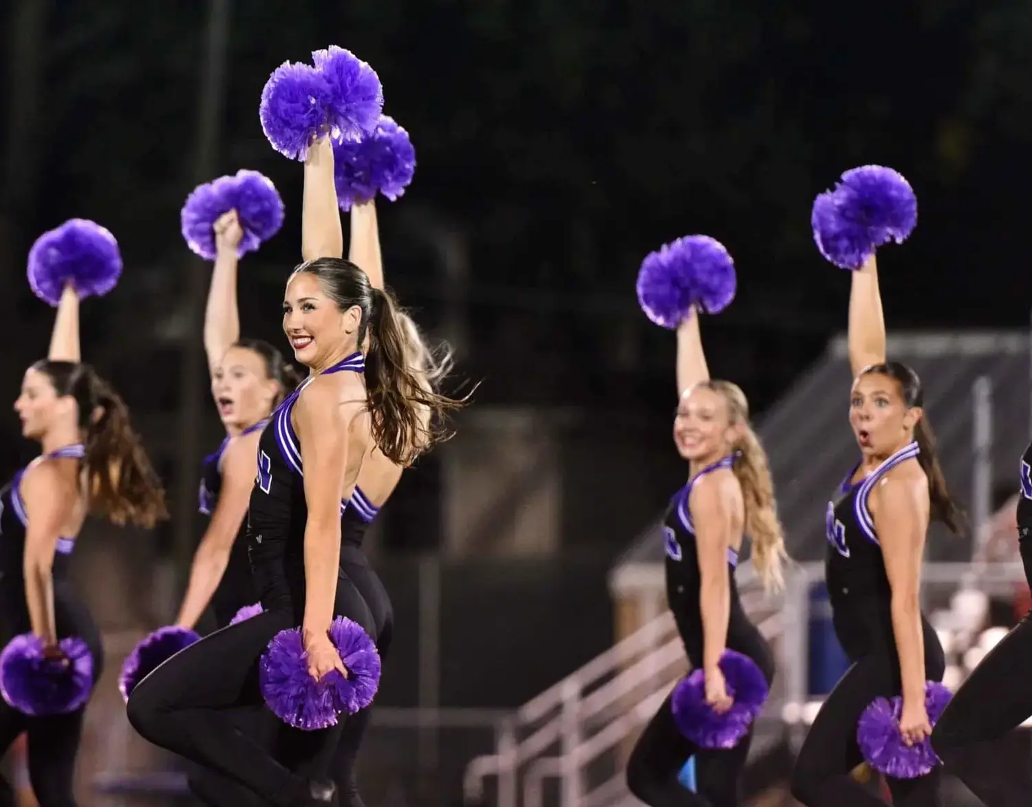 Notre Dame de Sion High School students cheerleading at an athletics game.
