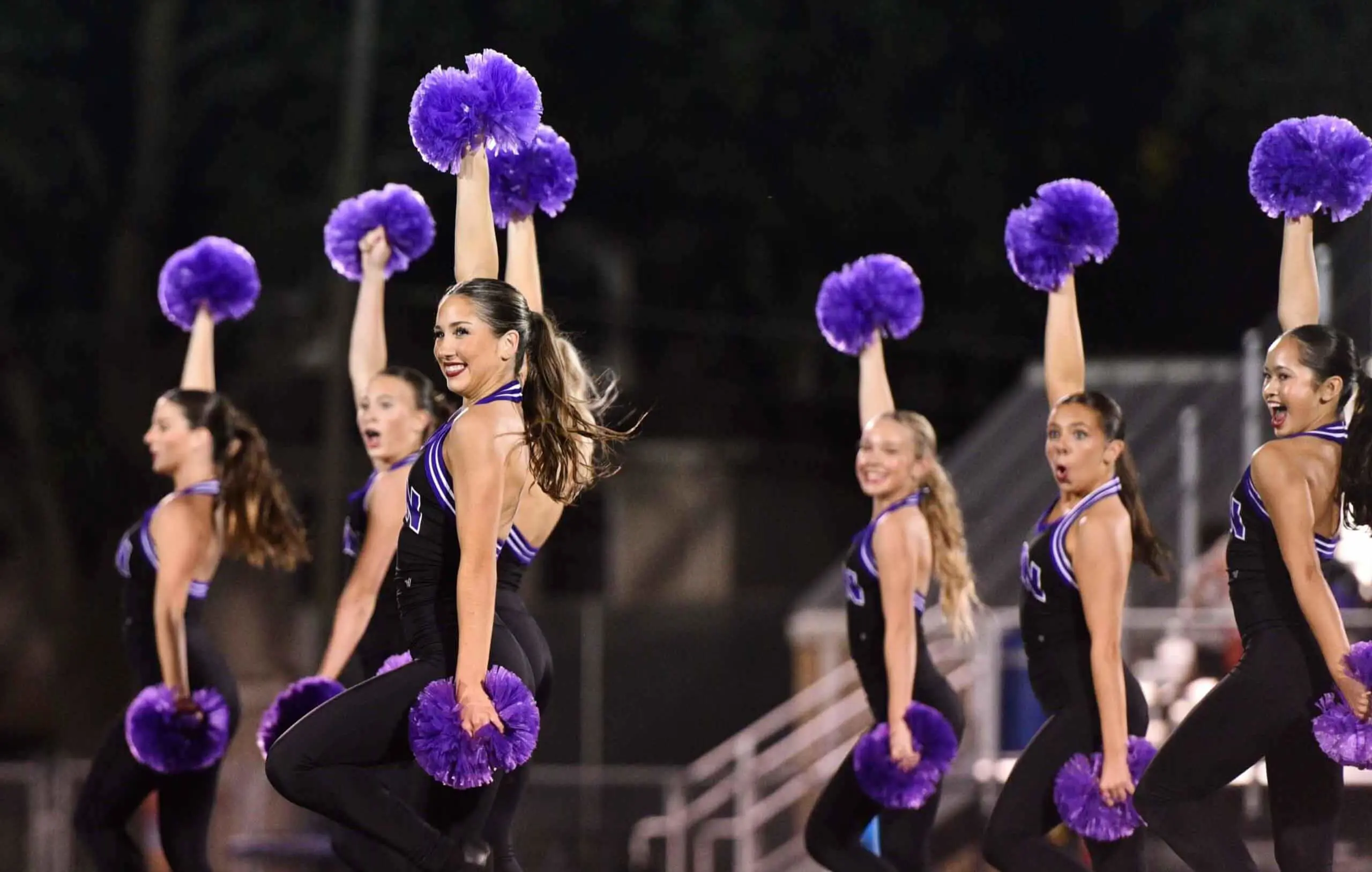 Notre Dame de Sion High School students cheerleading at an athletics game.