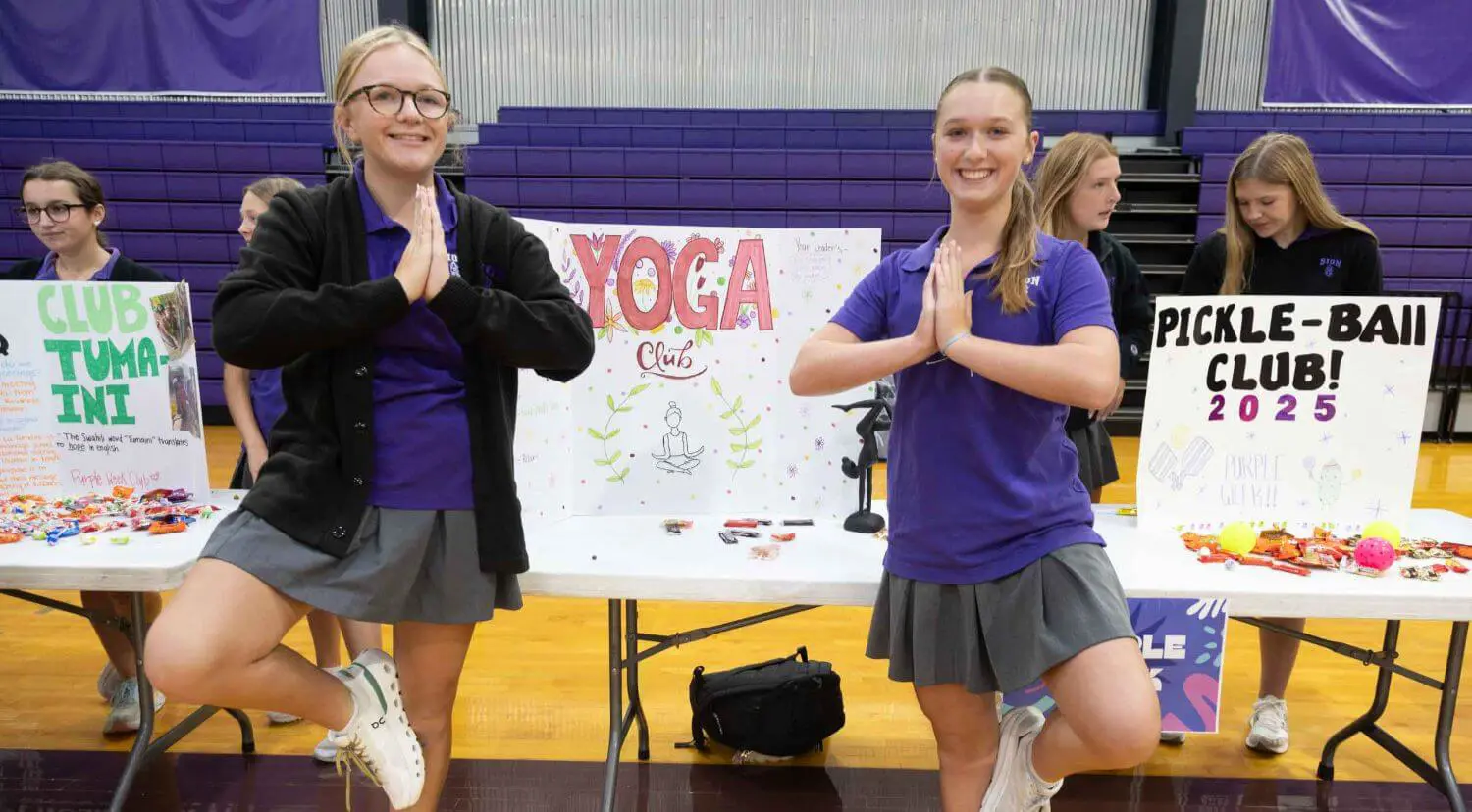 Notre Dame de Sion Yoga Club members at clubs fair in school gymnasium.