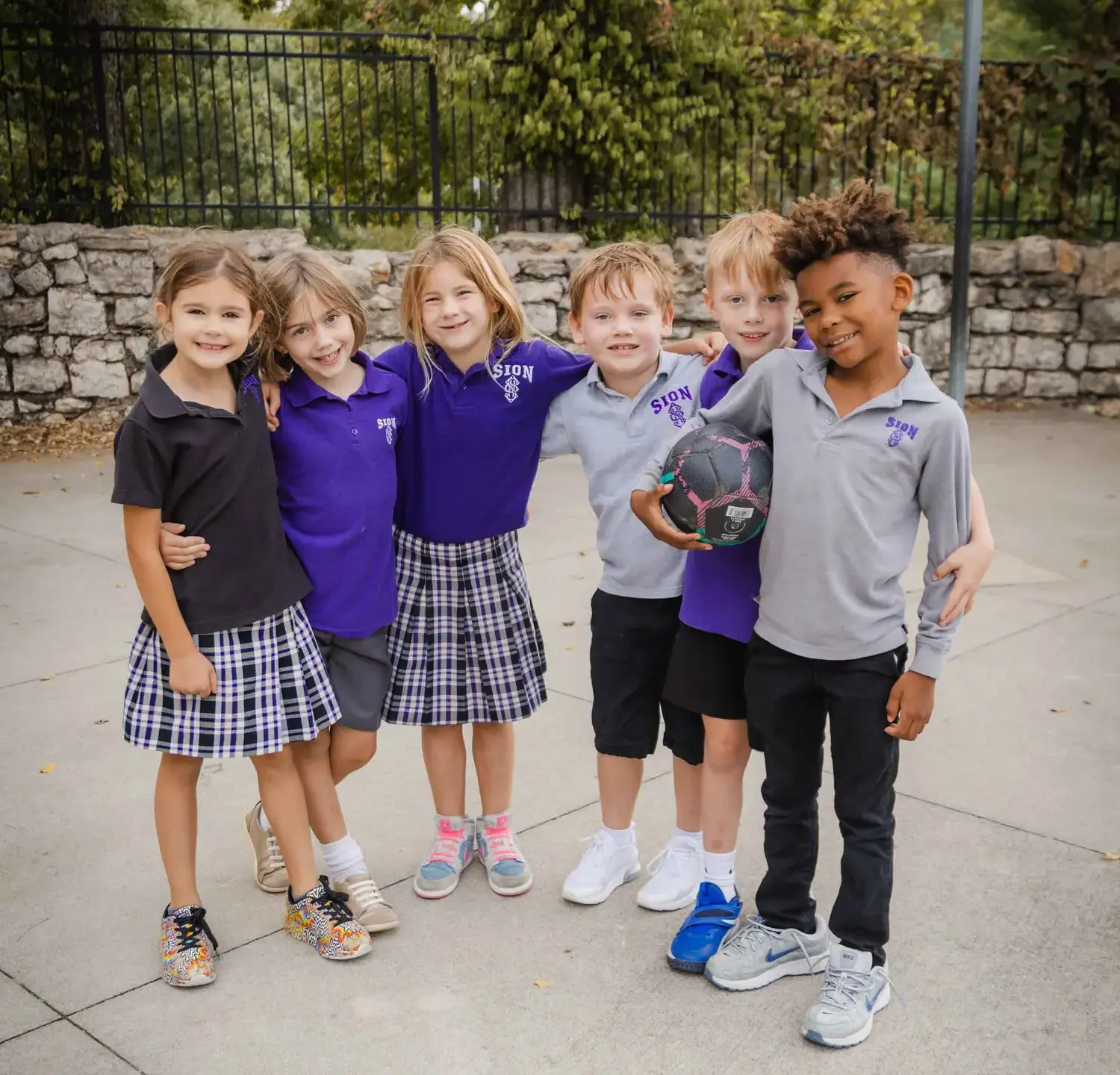 Notre Dame de Sion Grade School students smiling and wearing their school uniforms.