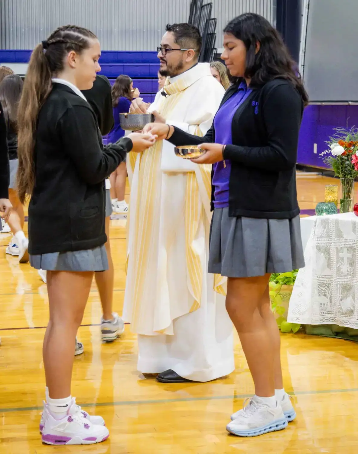 Notre Dame de Sion student dispensing the eucharist during mass.